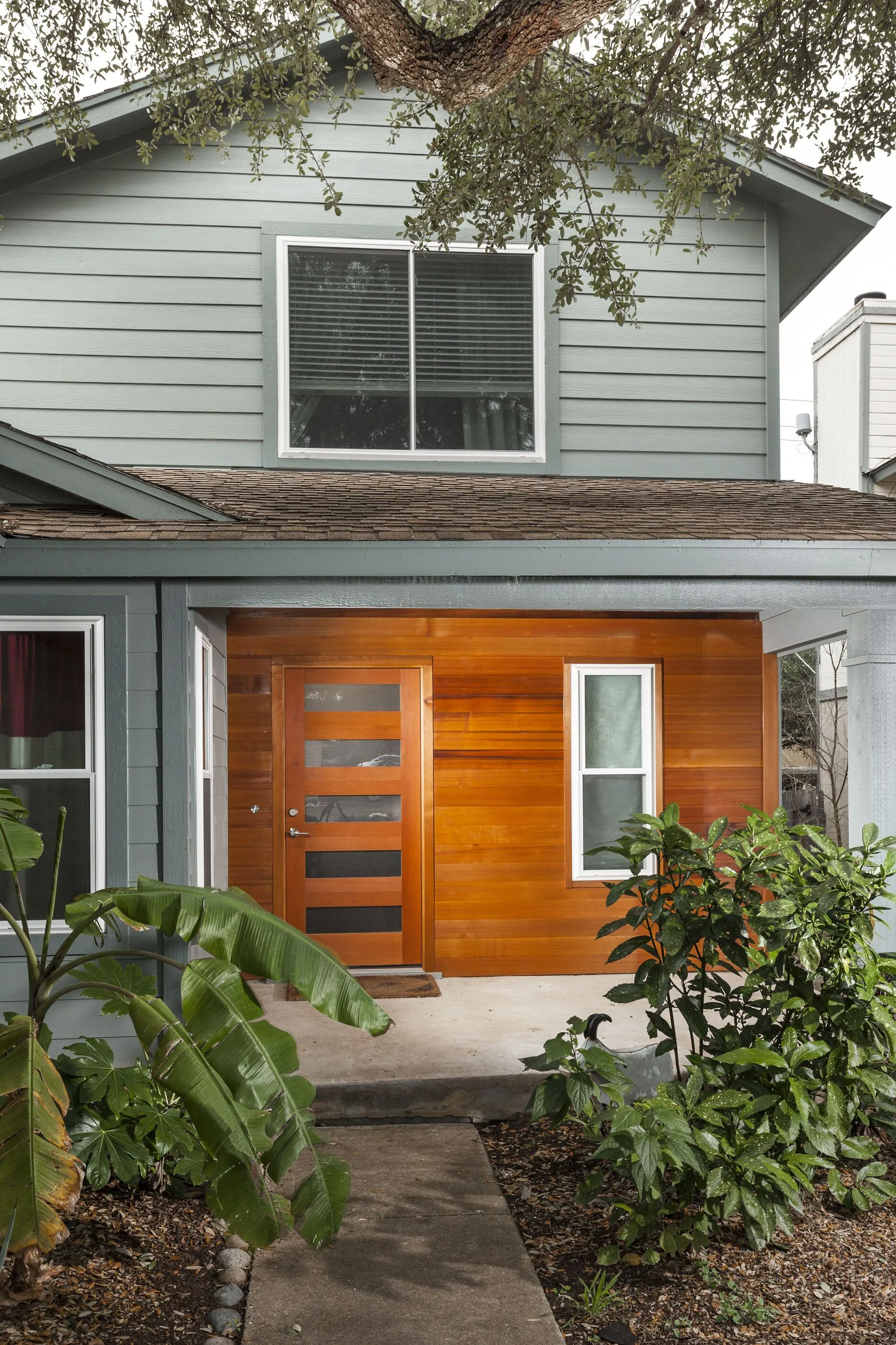 Modern Two-Story House with Green Siding and Wood Facade