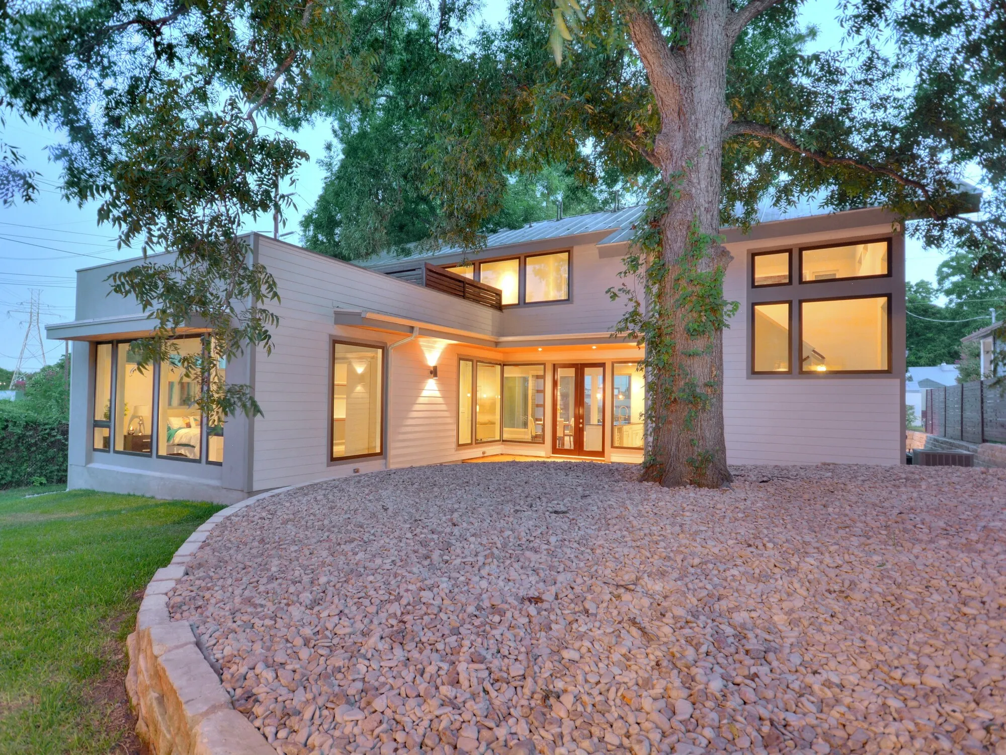 Modern House with Light Siding, Large Windows, and Warm Dusk Lighting