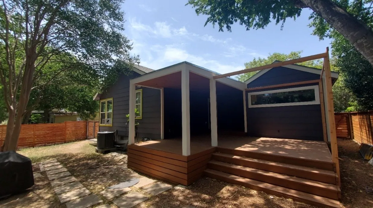 Backyard view of a large wooden patio with steps