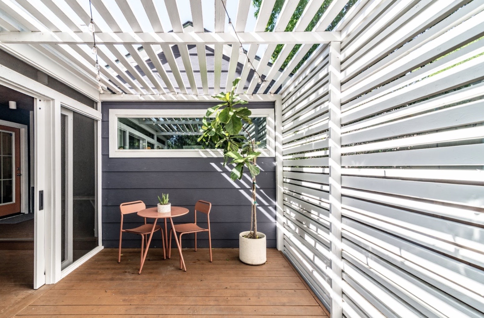 Patio with wood floors and white wood slatted shade cover