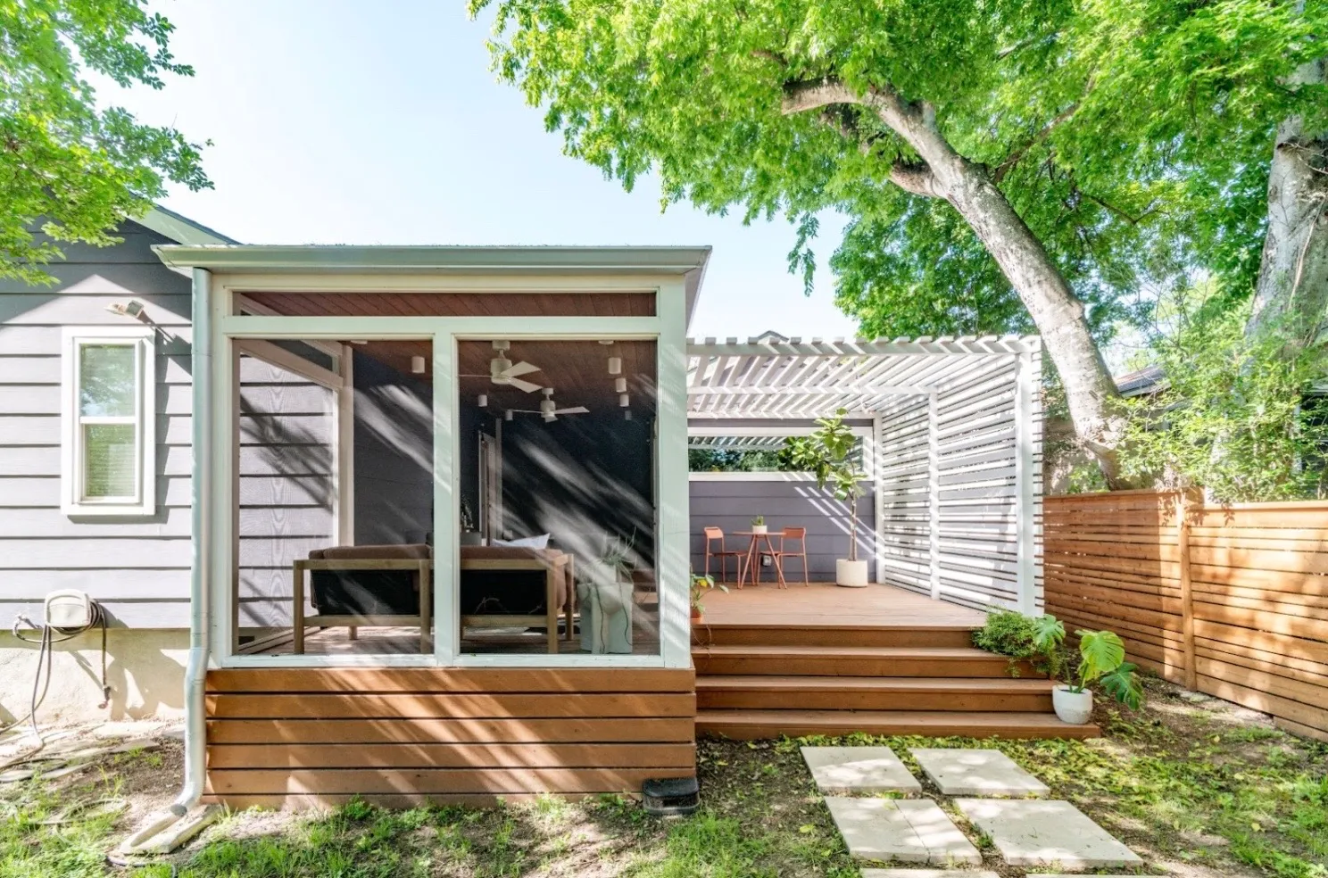 Patio with an enclosed sun room, and exposed area with white slatted shade