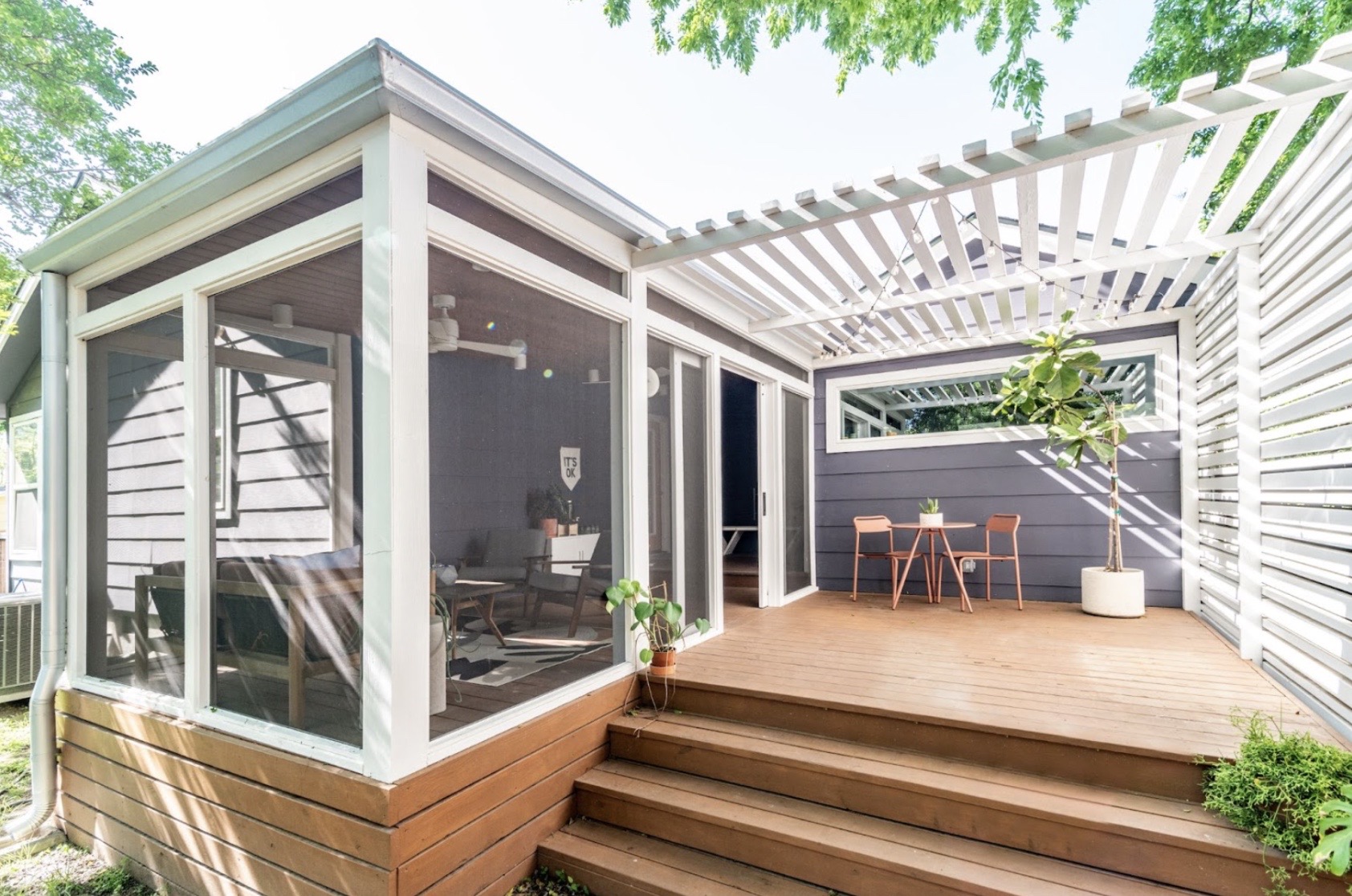 Outdoor patio with an enclosed sun room and exterior area with white slatted shade 