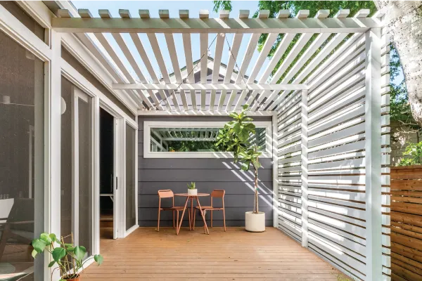 Wood patio with a white slat shade structure
