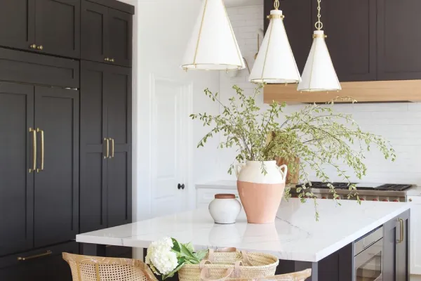 Dark cabinets and white cone pendant lights from a kitchen remodeling in Austin.