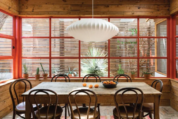 Wood walls, red-trimmed windows, and a round chandelier