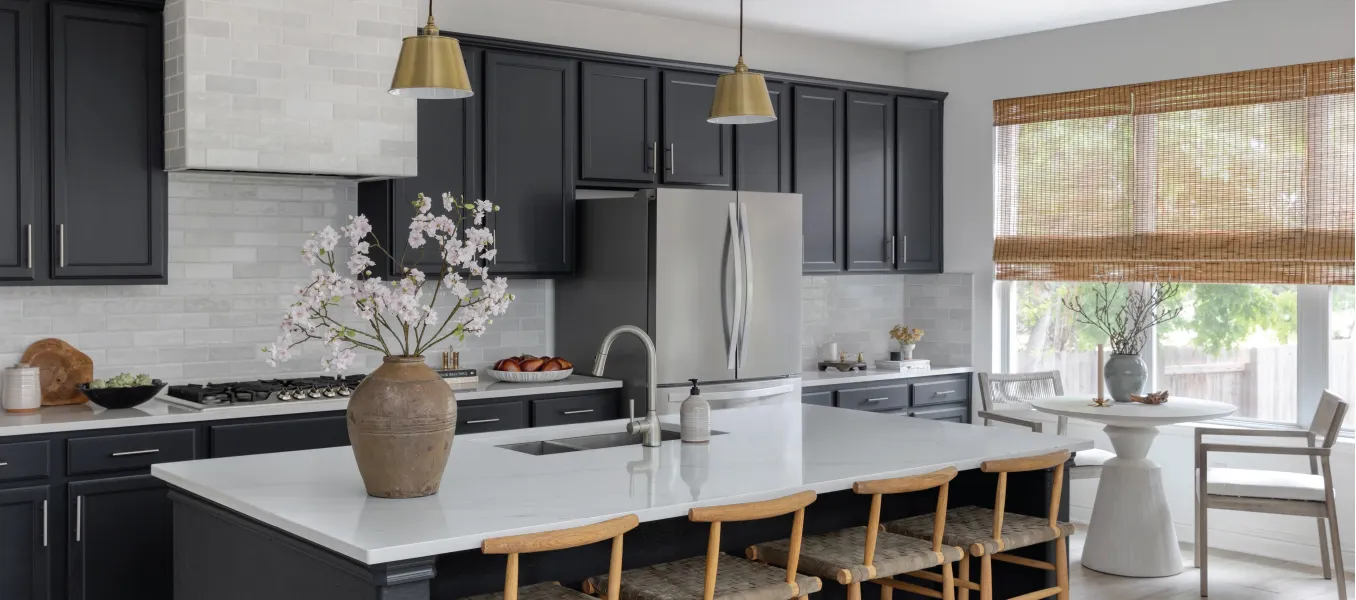High end kitchen with dark cabinets and a large kitchen island with light counter tops and a dining nook