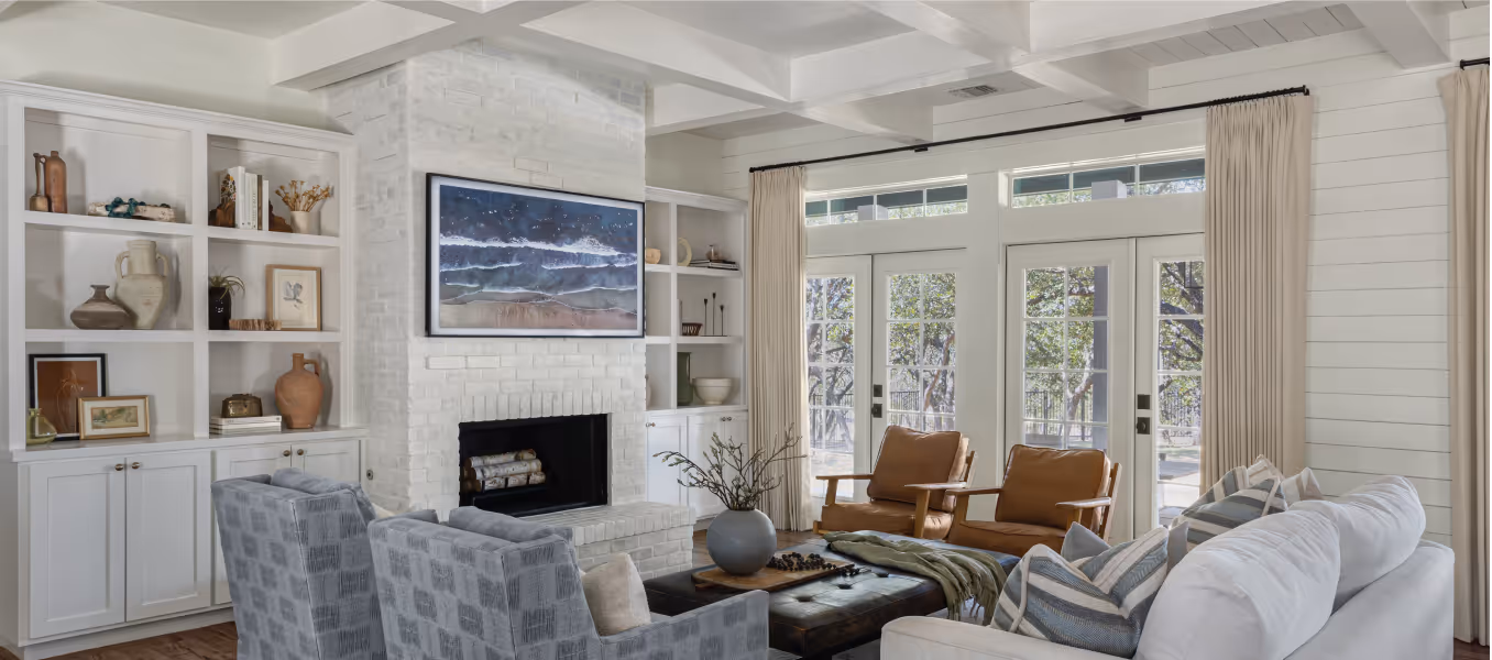 Living room with a fireplace, loveseat, four chairs, built-in cabinets and shelving, and french doors
