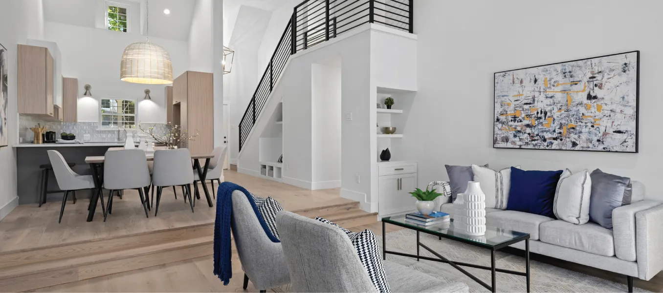Open concept living room, dining room and kitchen with an exposed staircase 