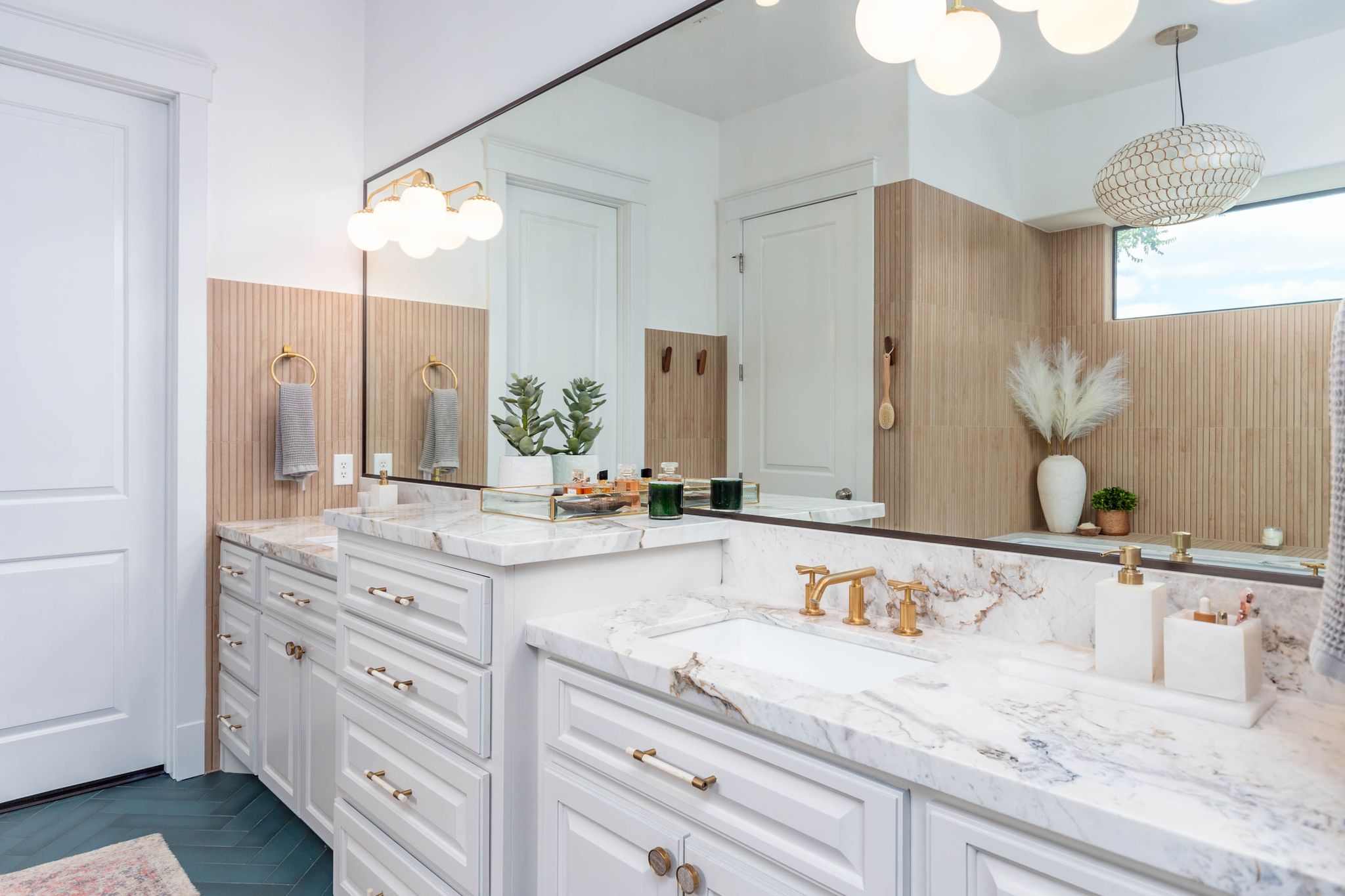Bathroom with two sinks, white cabinets, and a large mirror