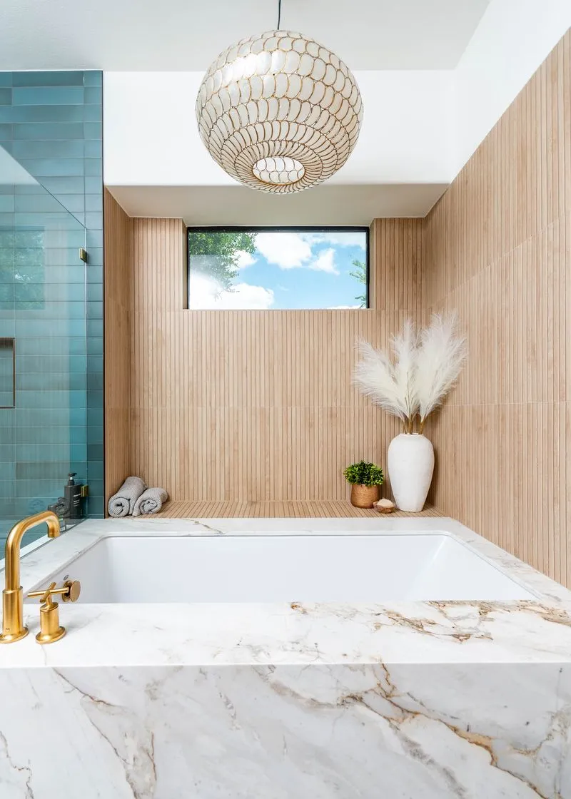 Large tube encased in marble with wood walls and a chandelier hanging above it
