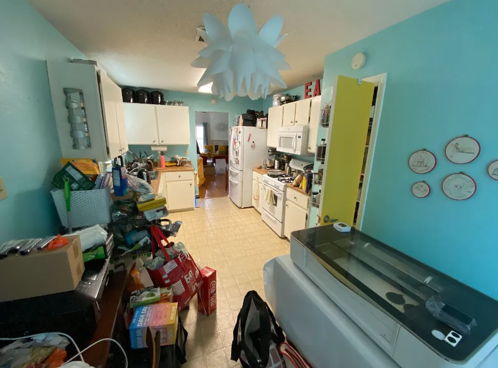 Kitchen with lots of clutter and light blue walls