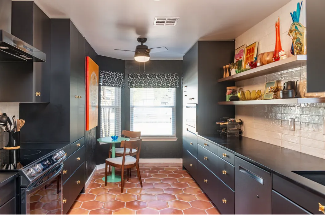 Galley style kitchen with terracotta hexagon tile flooring, dark blue cabinets, and white tile backsplash