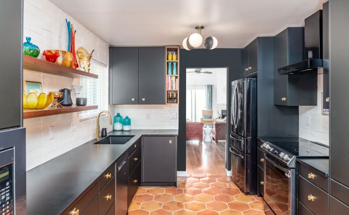 Galley style kitchen with terracotta hexagon tile flooring, dark blue cabinets, and white tile backsplash