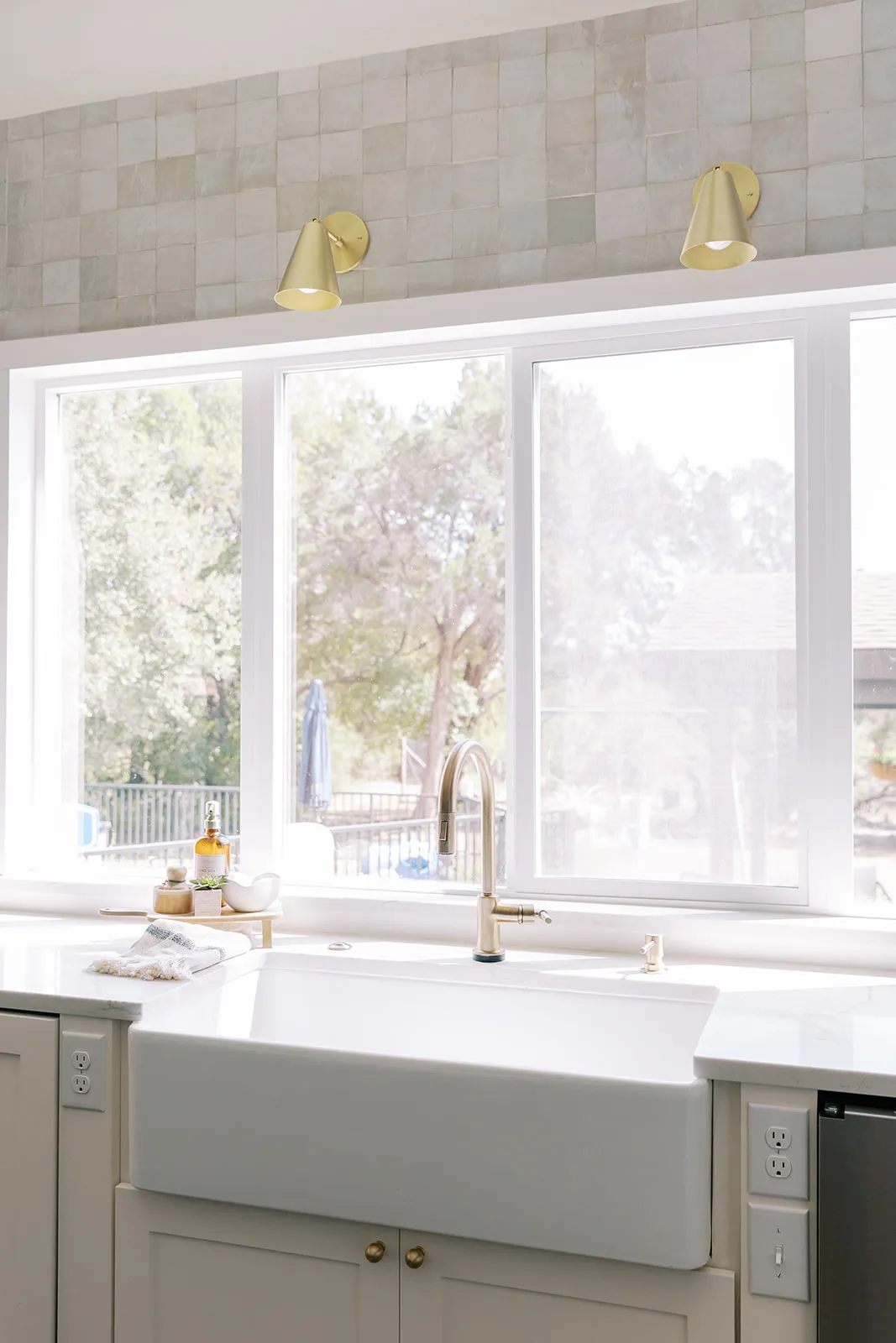 Farm-style kitchen sink with large windows behind it