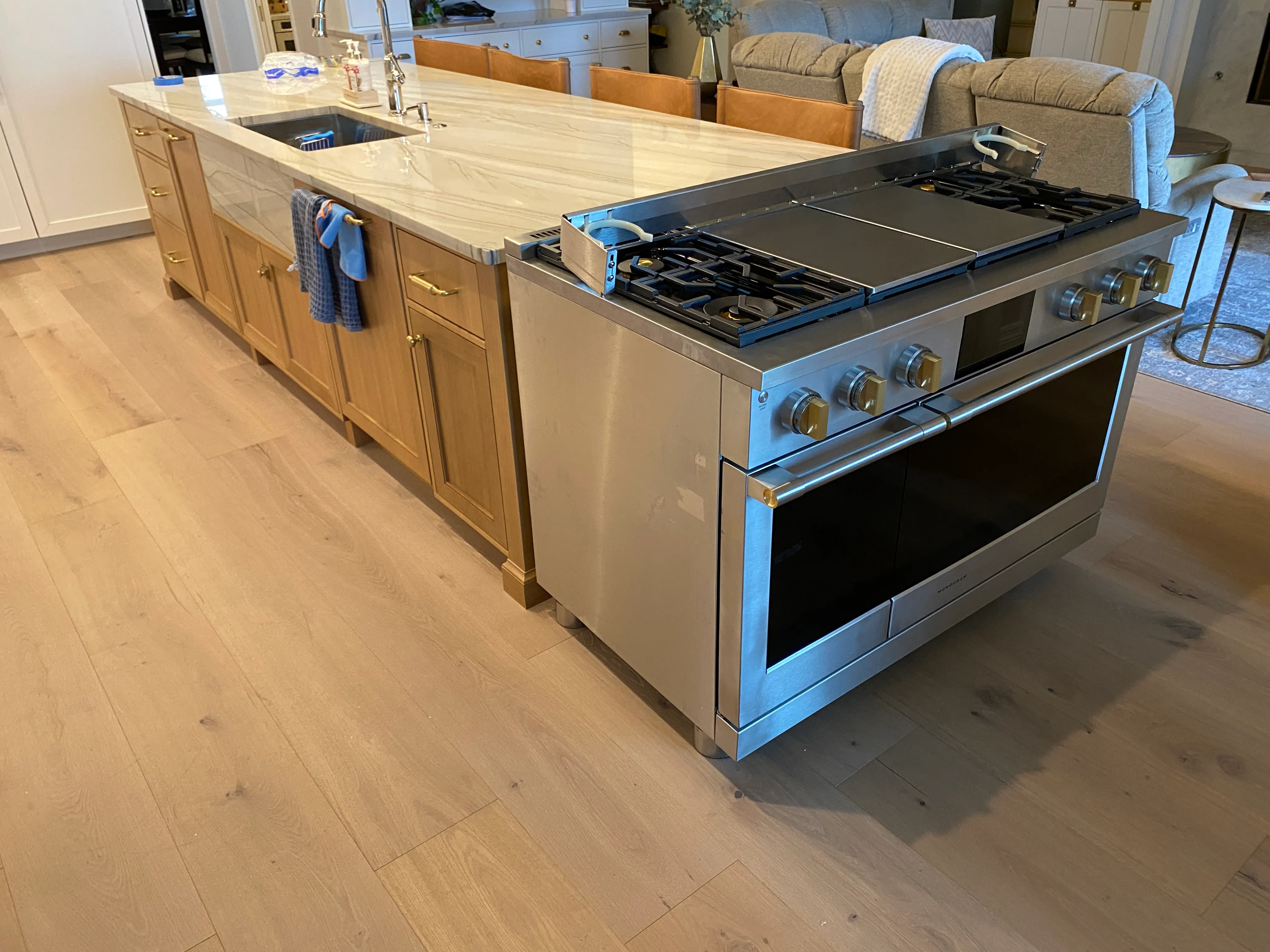 Marble island and wooden cabinets featured in a kitchen remodeling in Austin.