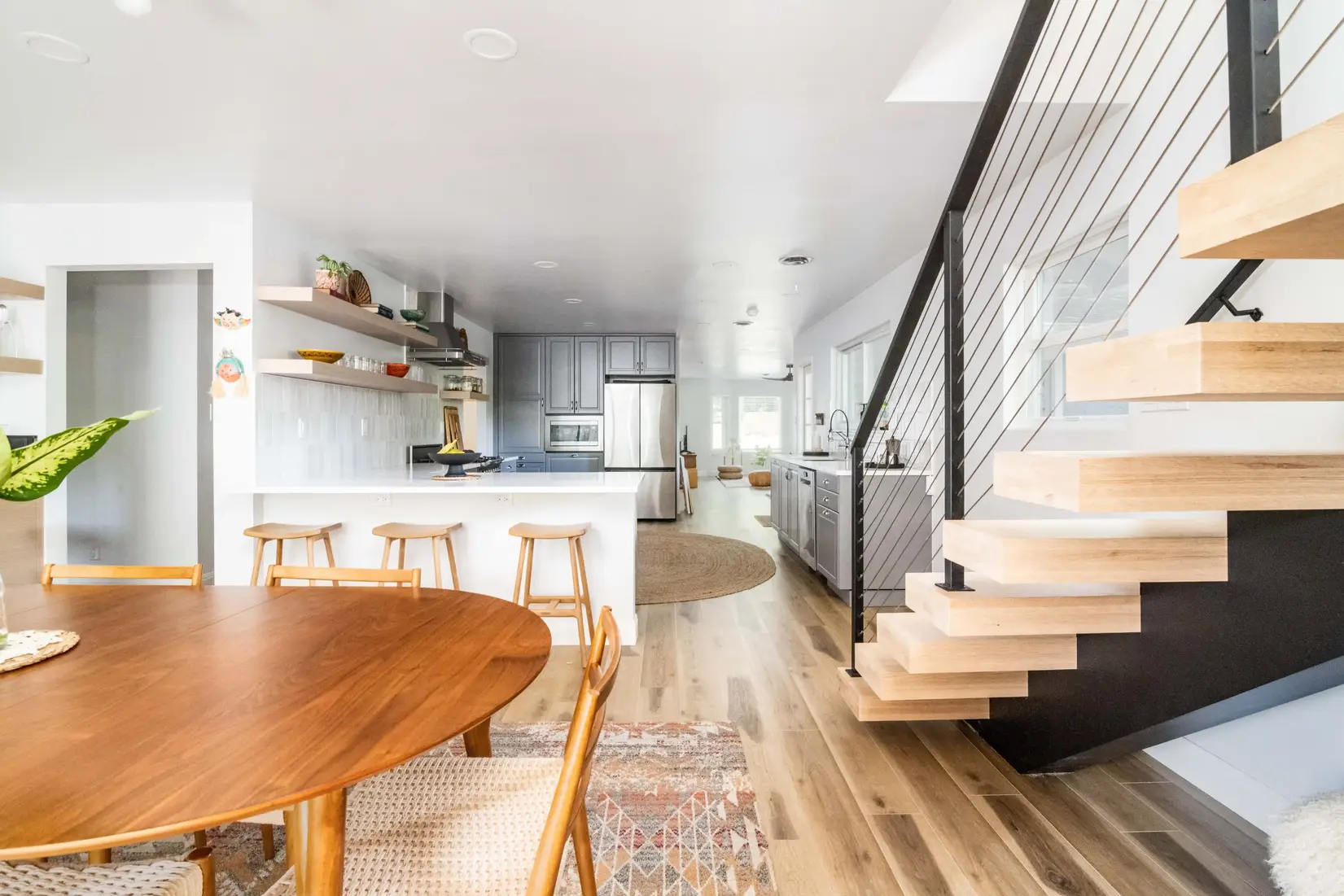 Open kitchen remodeling in austin with a dining area and floating staircase.