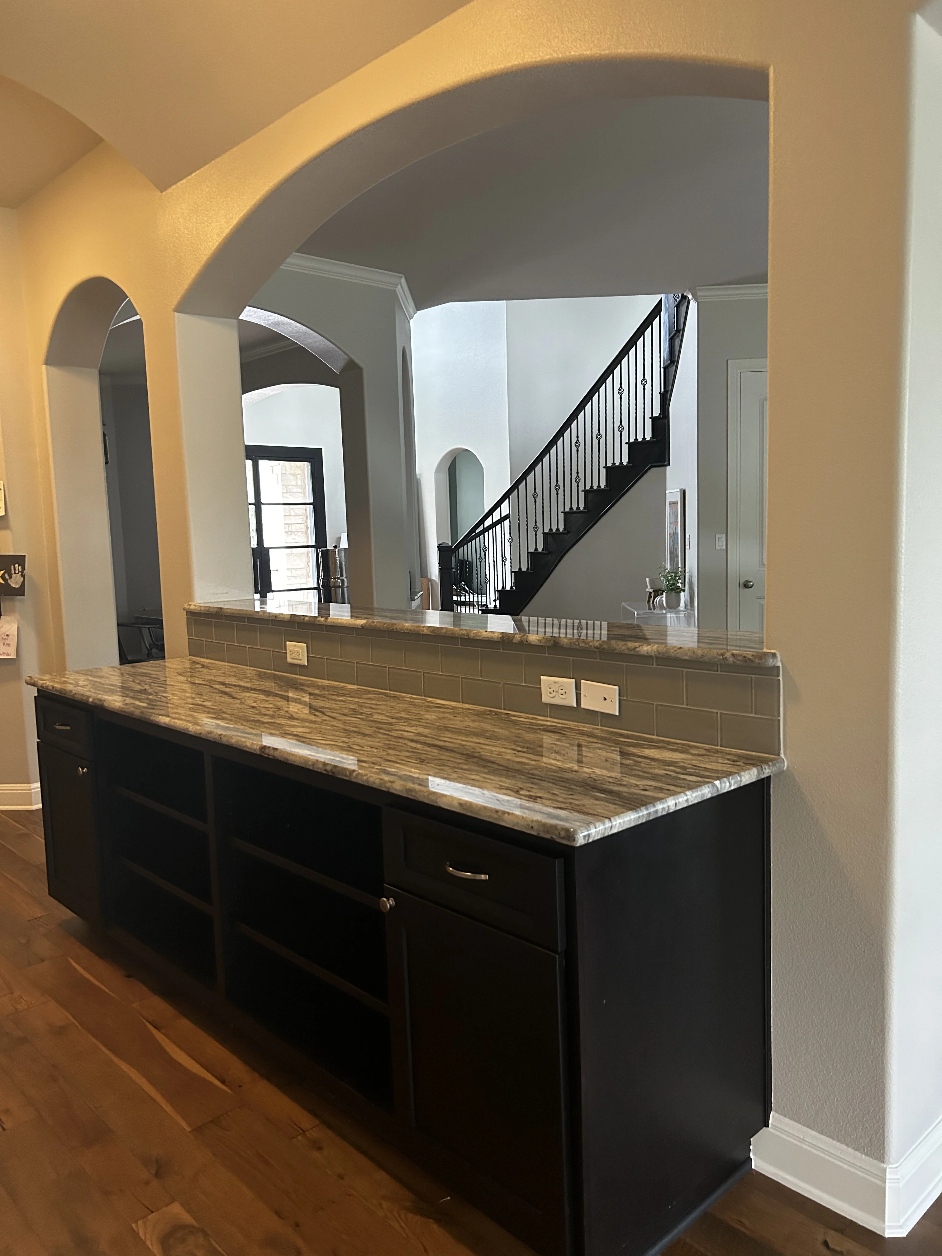 Renovated bathroom with brown tile, wood vanity, and a plastic-covered bathtub.
