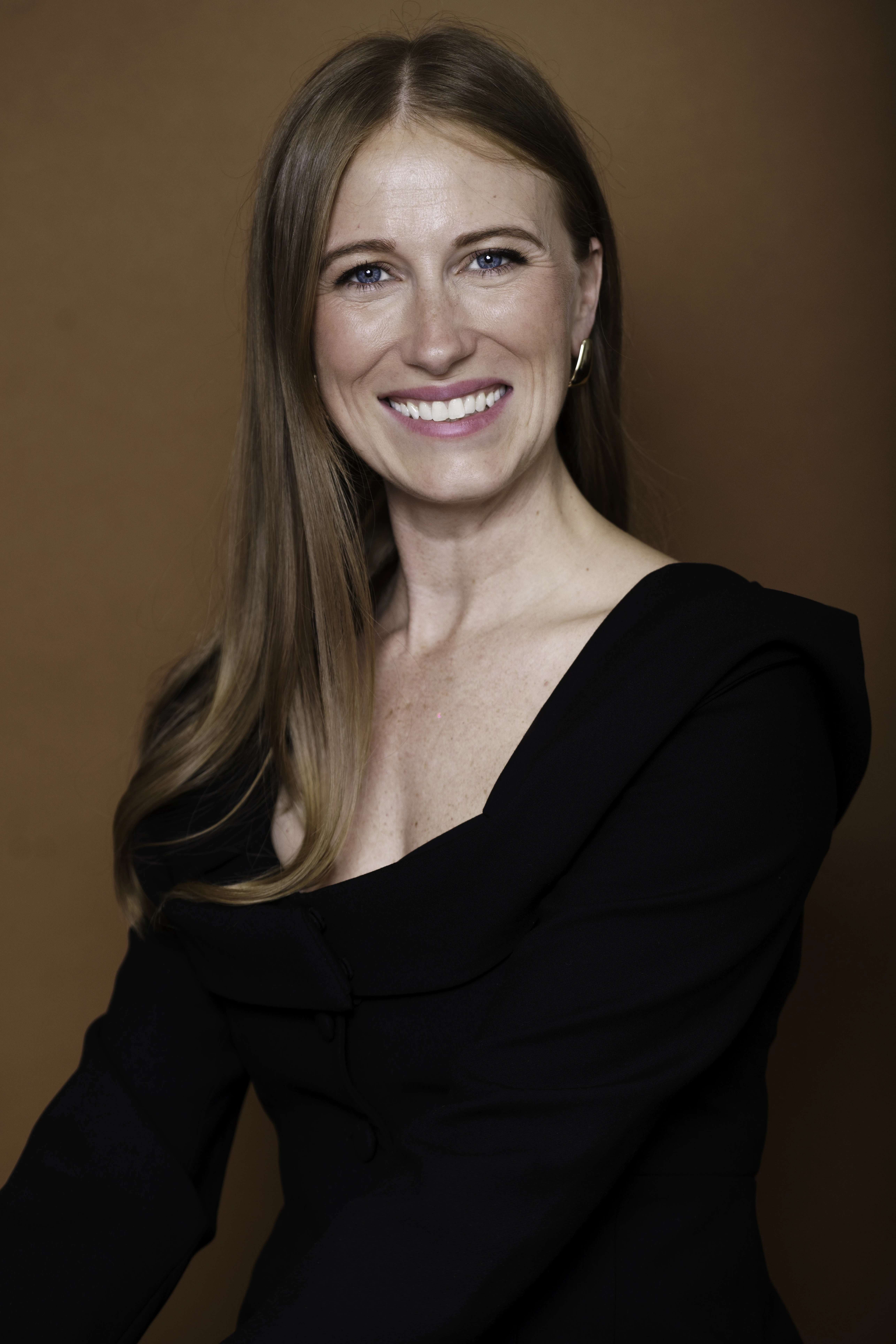 Ashley Wainscott posed against a plain brown background.