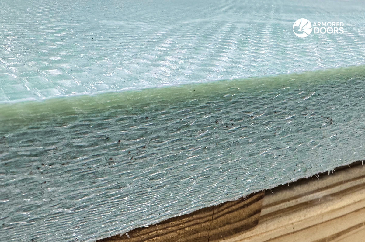Close-up of an Armored Doors ballistic fiberglass panel showing its woven surface and dense layered composite edge.