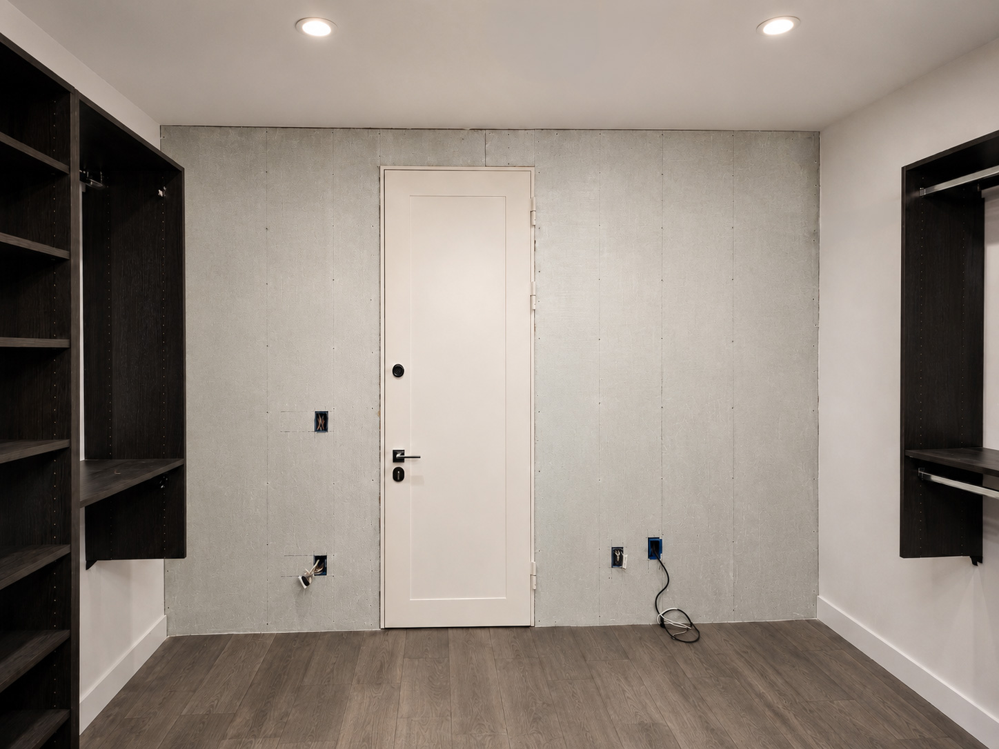Closet safe room before finishing, with Armored Doors ballistic fiberglass panels exposed around a white security door