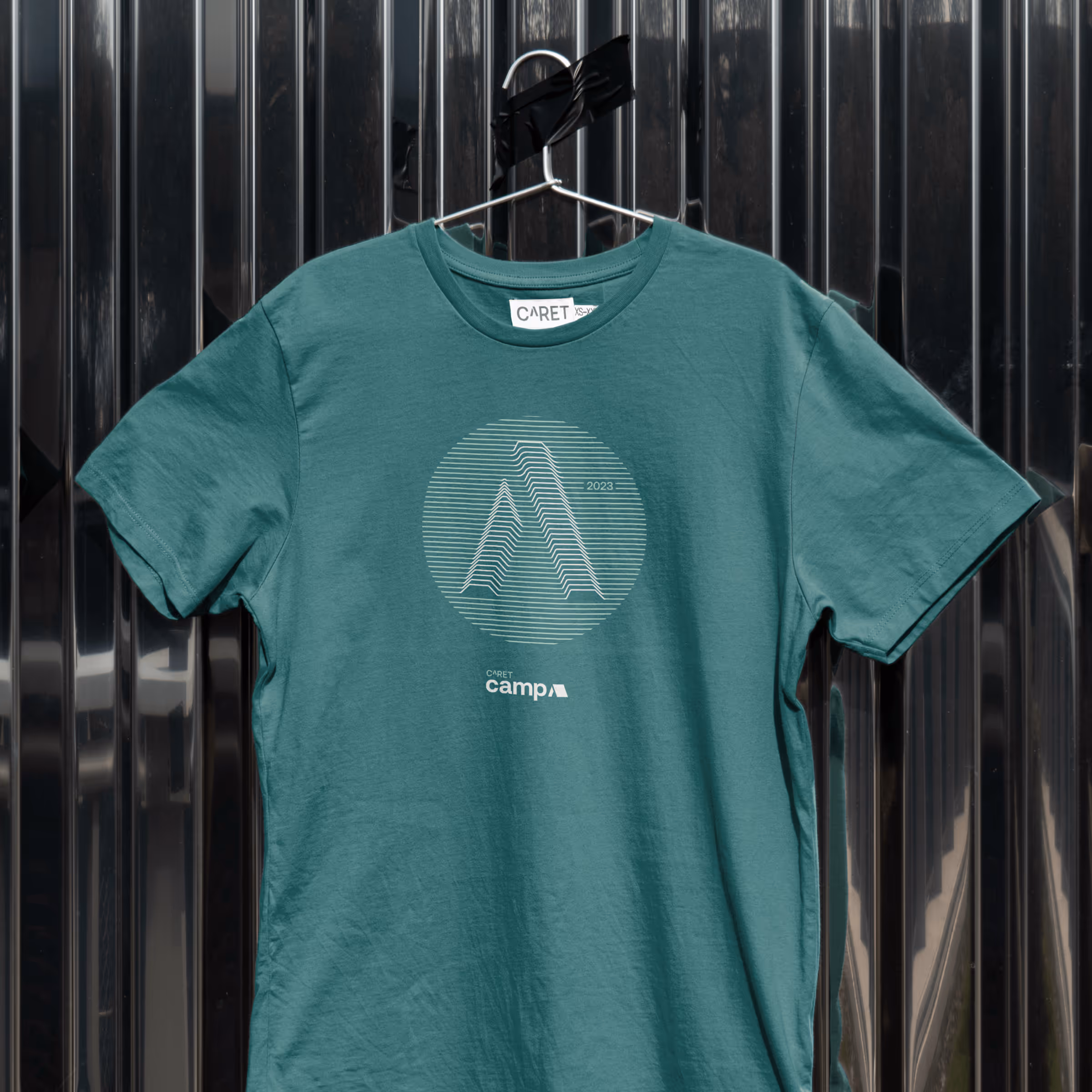 A mockup showing the CARET Camp tee shirt design