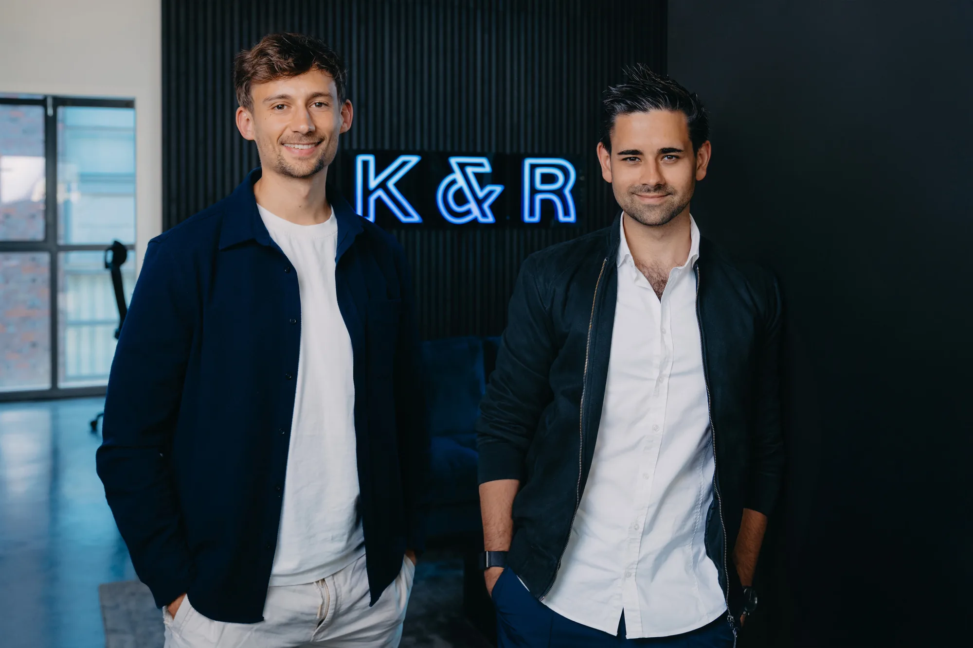 Gruenderduo Klein und Rose vor K&R-Neonlogo