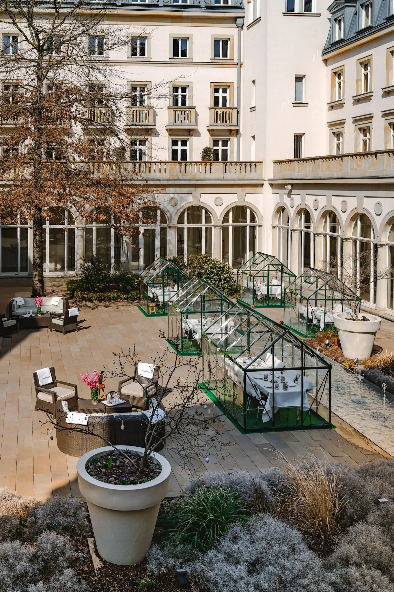 Glashaus-Restaurants im Arkadeninnenhof der Villa Kennedy mit Frühlingspflanzung – Villa Kennedy Ostern