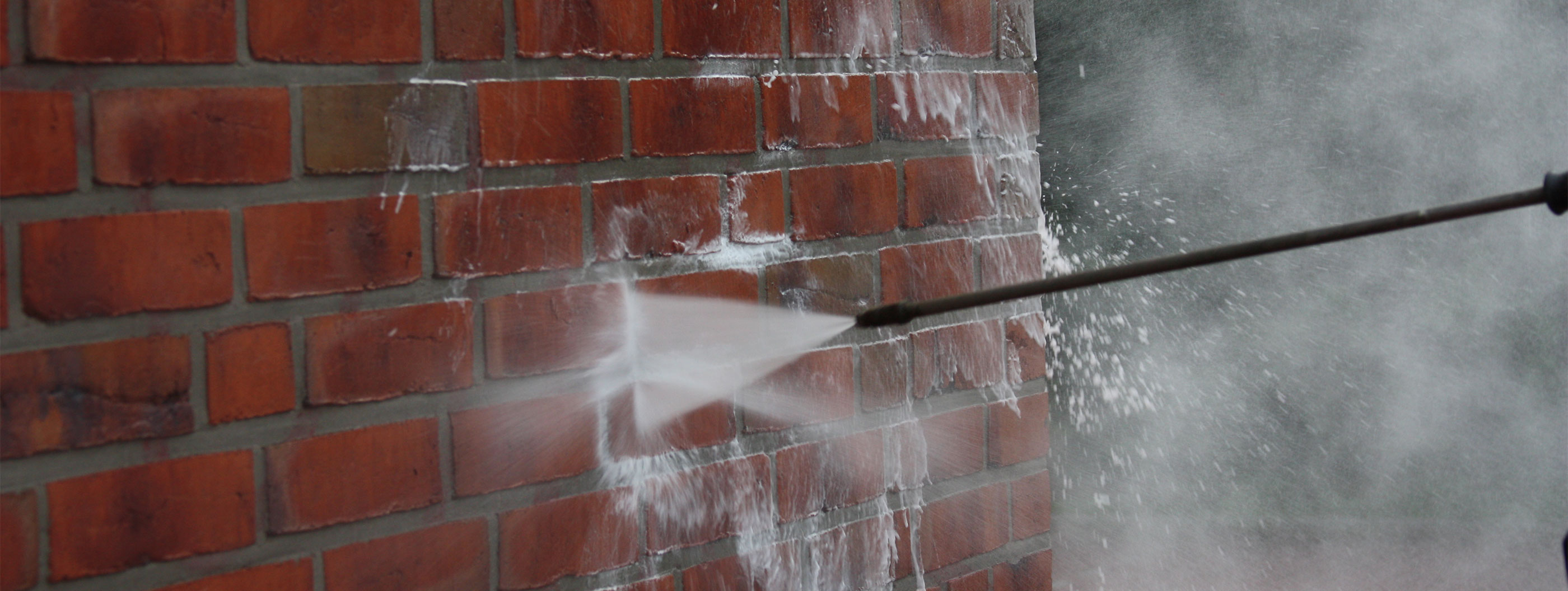 Pressure washer cleaning graffiti.