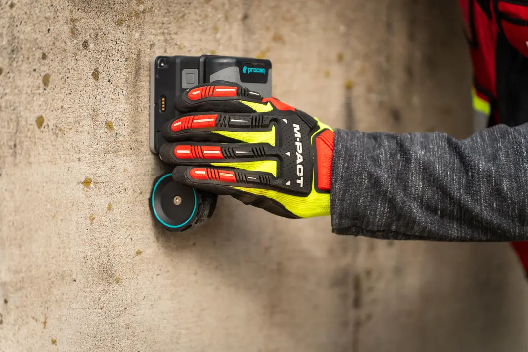 A hand holding a ground penetrating radar scanner.