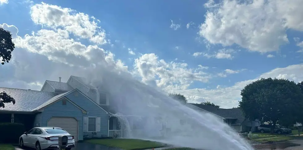 A geyser of water dousing a house.