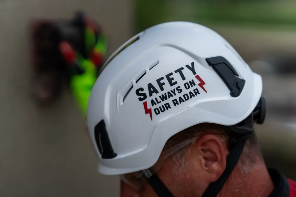 Close-up of a white hardhat emblazoned with the words ‘Safety Always On Our Radar’.