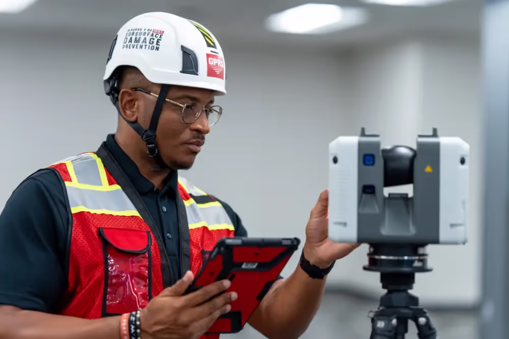 A GPRS Project Manager operating a 3D laser scanner while holding a tablet.