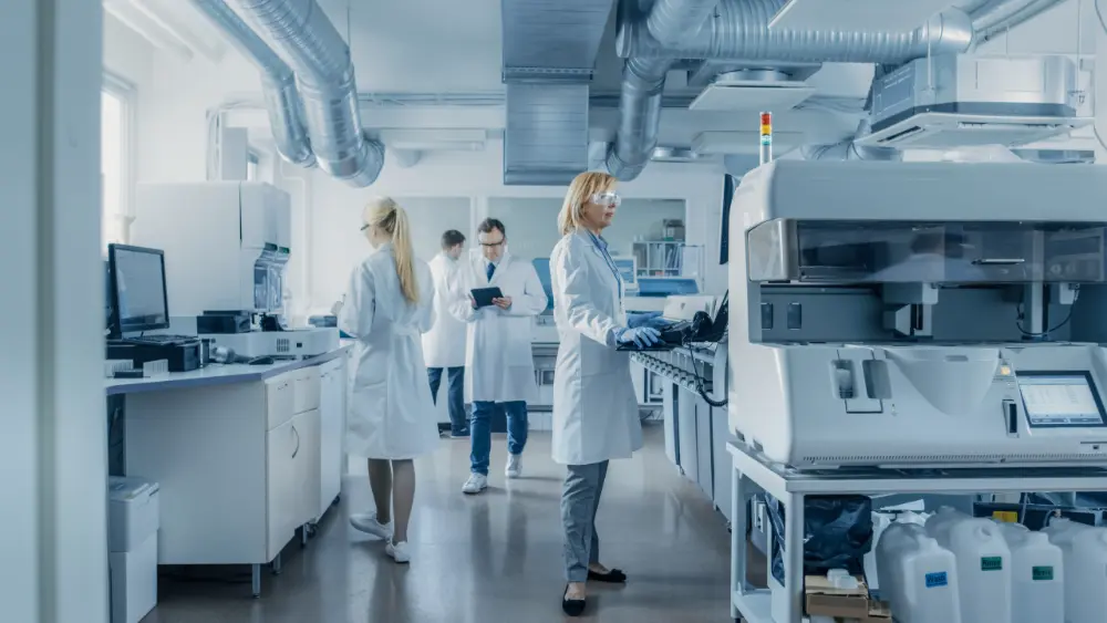 Medical professionals working at a equipment in a lab.