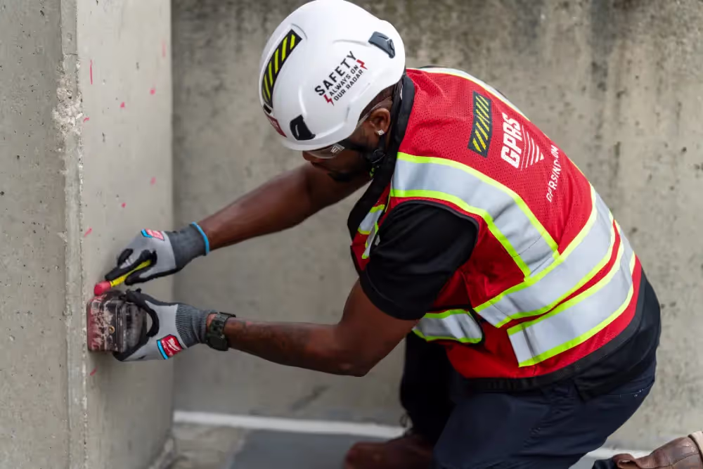 A GPRS Project Manager uses a ground penetrating radar scanner on a concrete pillar.