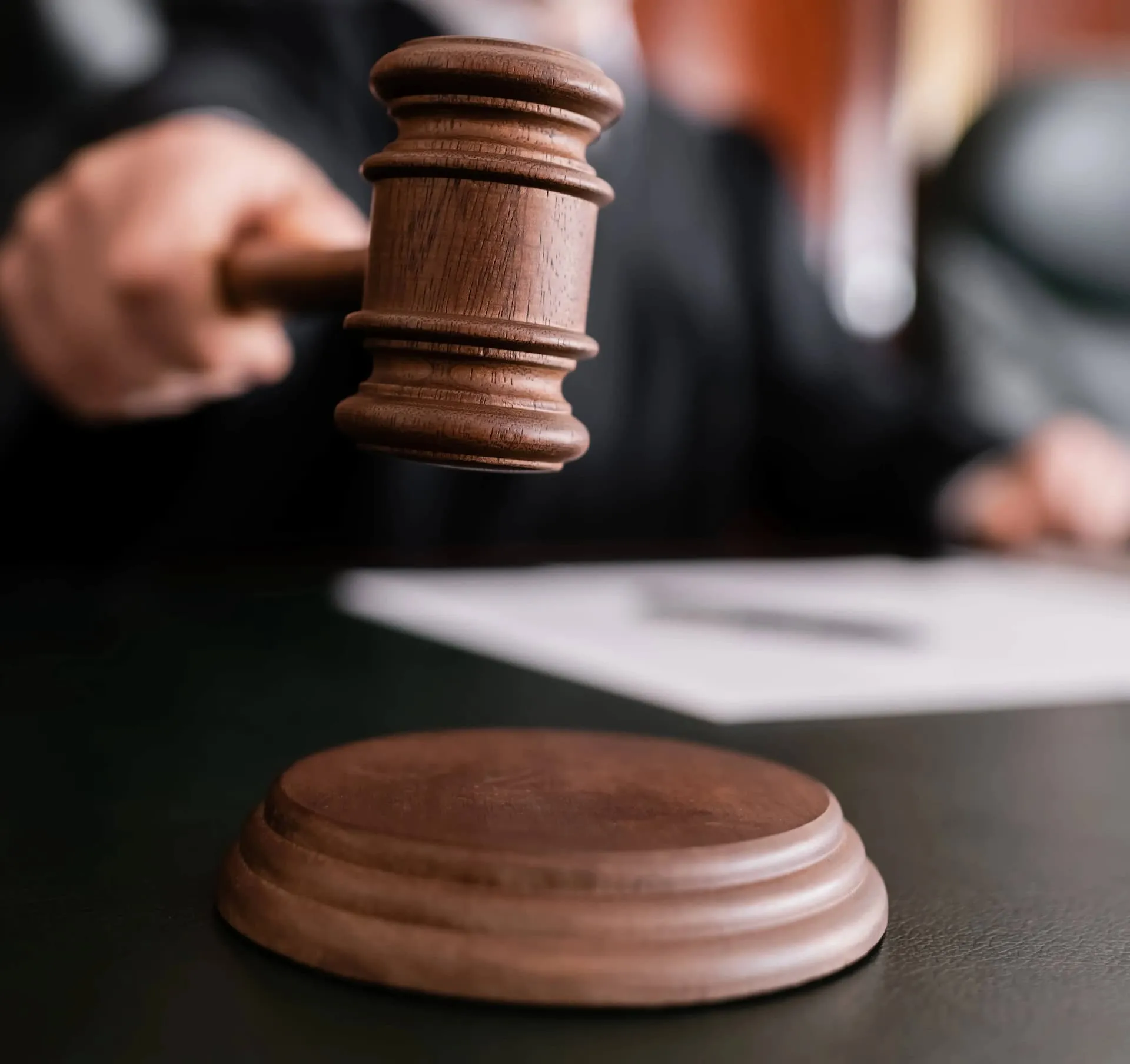 A judge's gavel over a wooden block.