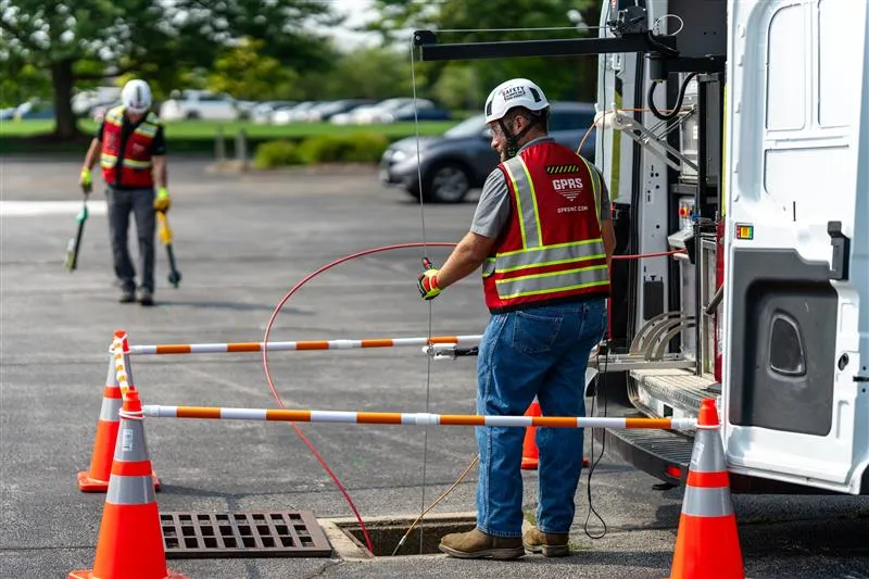 GPRS Project Managers conducting utility locating and sewer pipe inspection services in a parking lot.