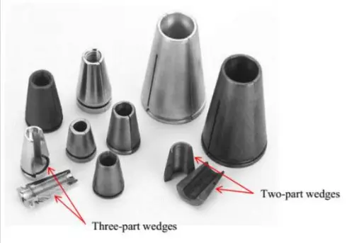 A grouping of several sizes and types of steel anchor wedges, some in two parts, and some in three parts. They are cylindrical cones that taper from wide to small openings, with serrations that secure to the cable during prestressing.