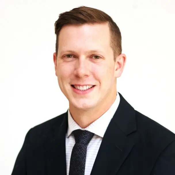 Boon Bowling pictured on a white background, wearing a black suit.