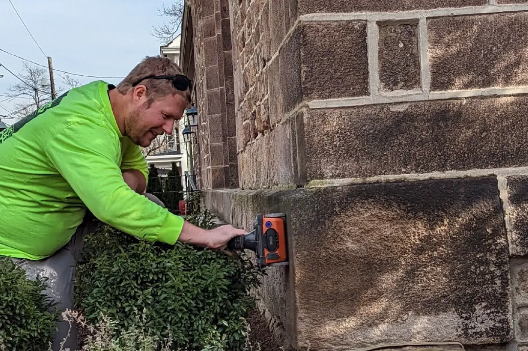 A worker performs a GPR scan on a concrete block.