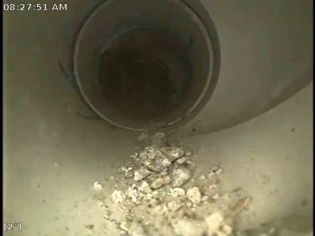 Screenshot of sewer inspection footage with debris in the bottom of a sewer pipe.