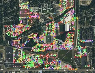 A satellite image with green, pink, red, and yellow circles and lines representing underground utilities.