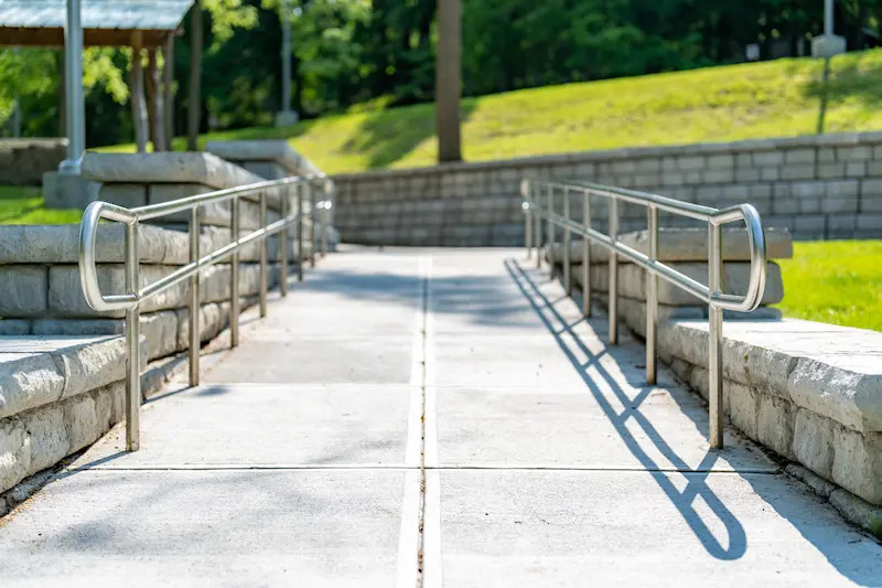 View up a concrete ramp with metal railings on either side.