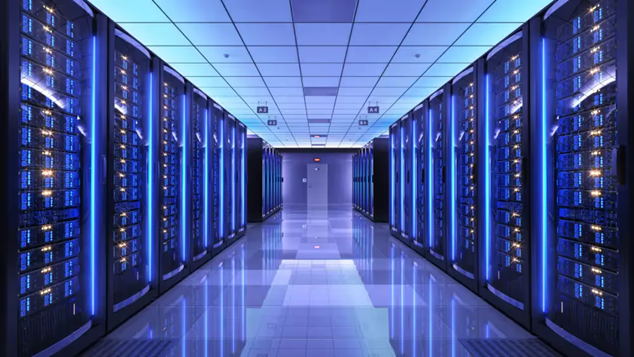 A hall of data centers illuminated with blue and purple light.