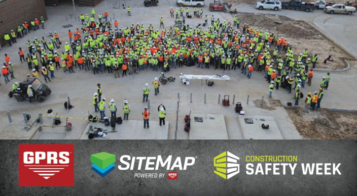 A drone image of a large group of construction workers wearing high-visibility clothing and helmets during a presentation on a concrete job site. In the bottom fourth of the image is a graphic rectangle that resembles concrete and features the GPRS logo, SiteMap logo, and Construction Safety Week logo.
