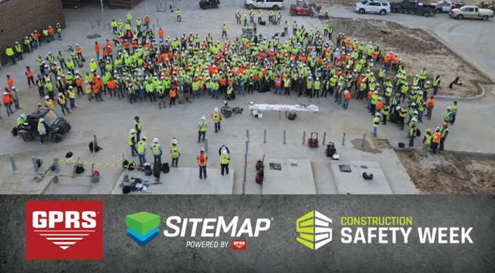 A drone image of a large group of construction workers wearing high-visibility clothing and helmets during a presentation on a concrete job site. In the bottom fourth of the image is a graphic rectangle that resembles concrete and features the GPRS logo, SiteMap logo, and Construction Safety Week logo. 