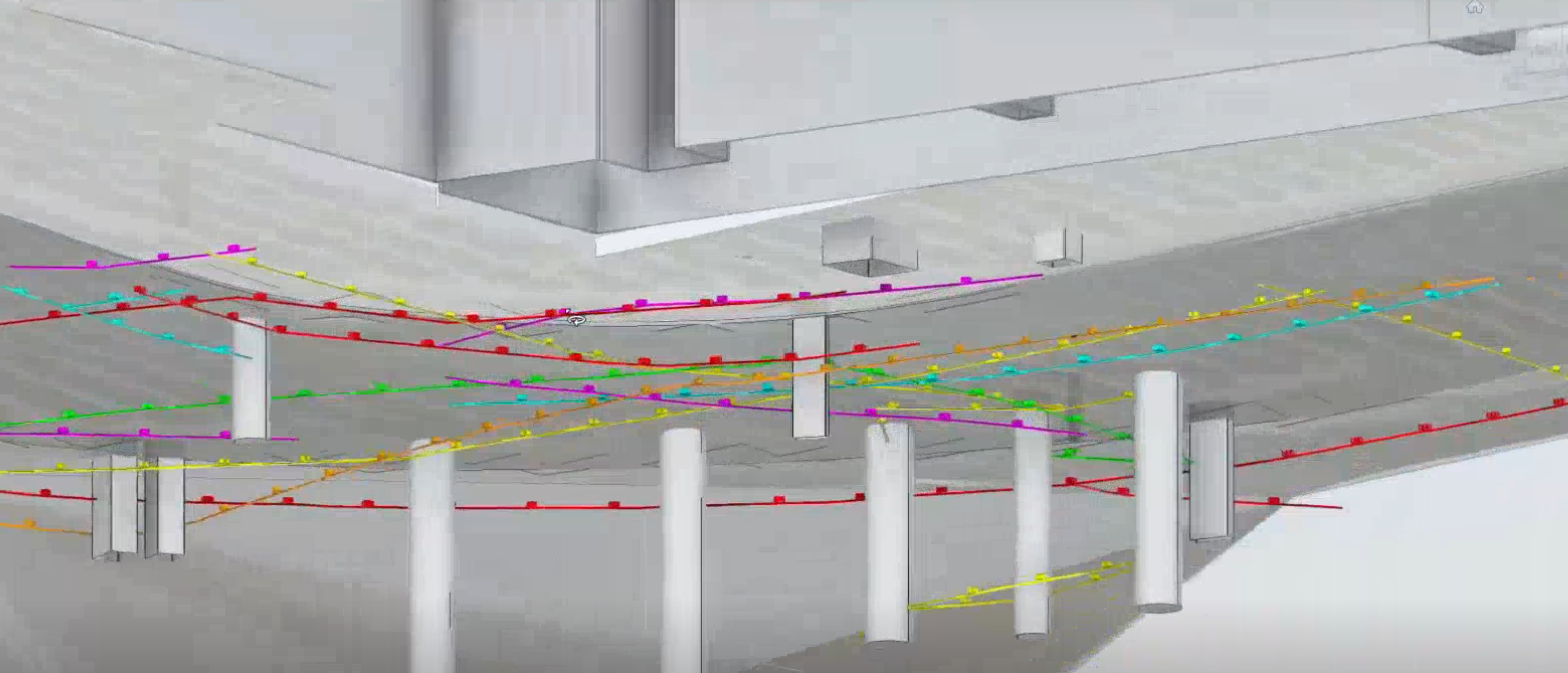 A grey and white 3D model of a site with blue, yellow, purple, red, and green lines and circles representing underground utilities. 