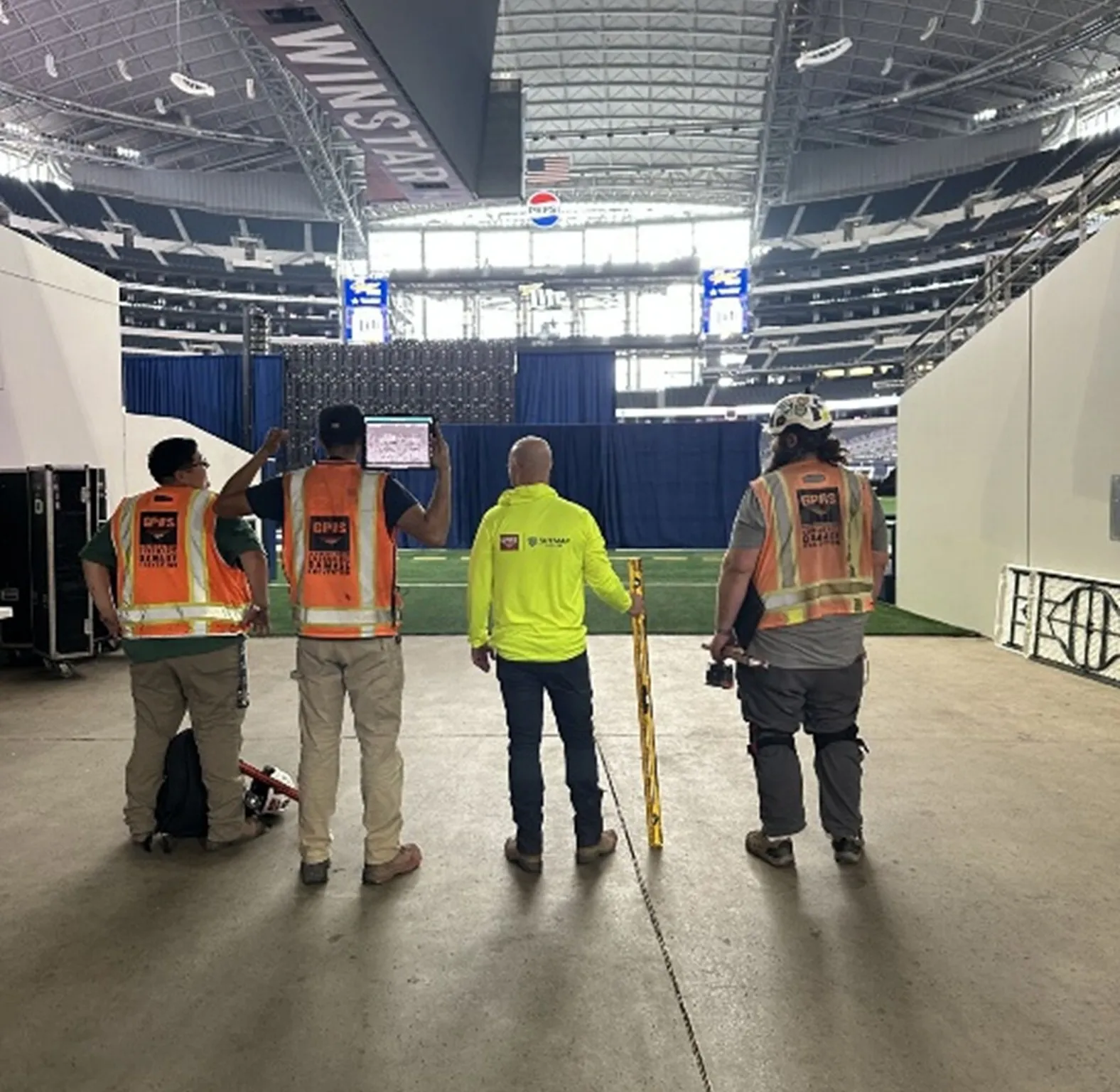 Four GPRS Project Managers wearing high visibility clothing. Each of them are holding equipment like a tablet, a straight edge, and ground penetrating radar (GPR). 