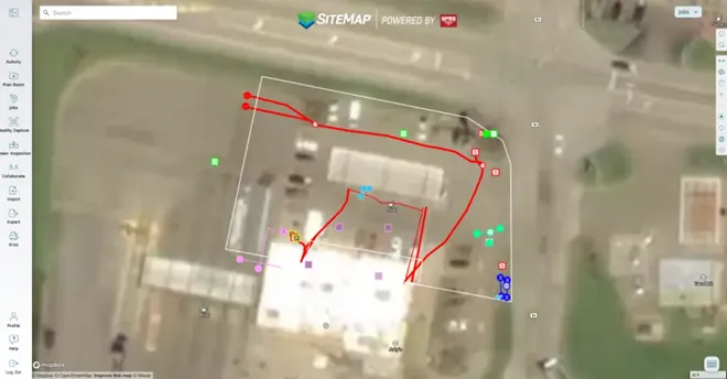 A satellite image of a facility on the SiteMap platform with white, red, blue, and green lines representing subsurface utilities and the scan area. 