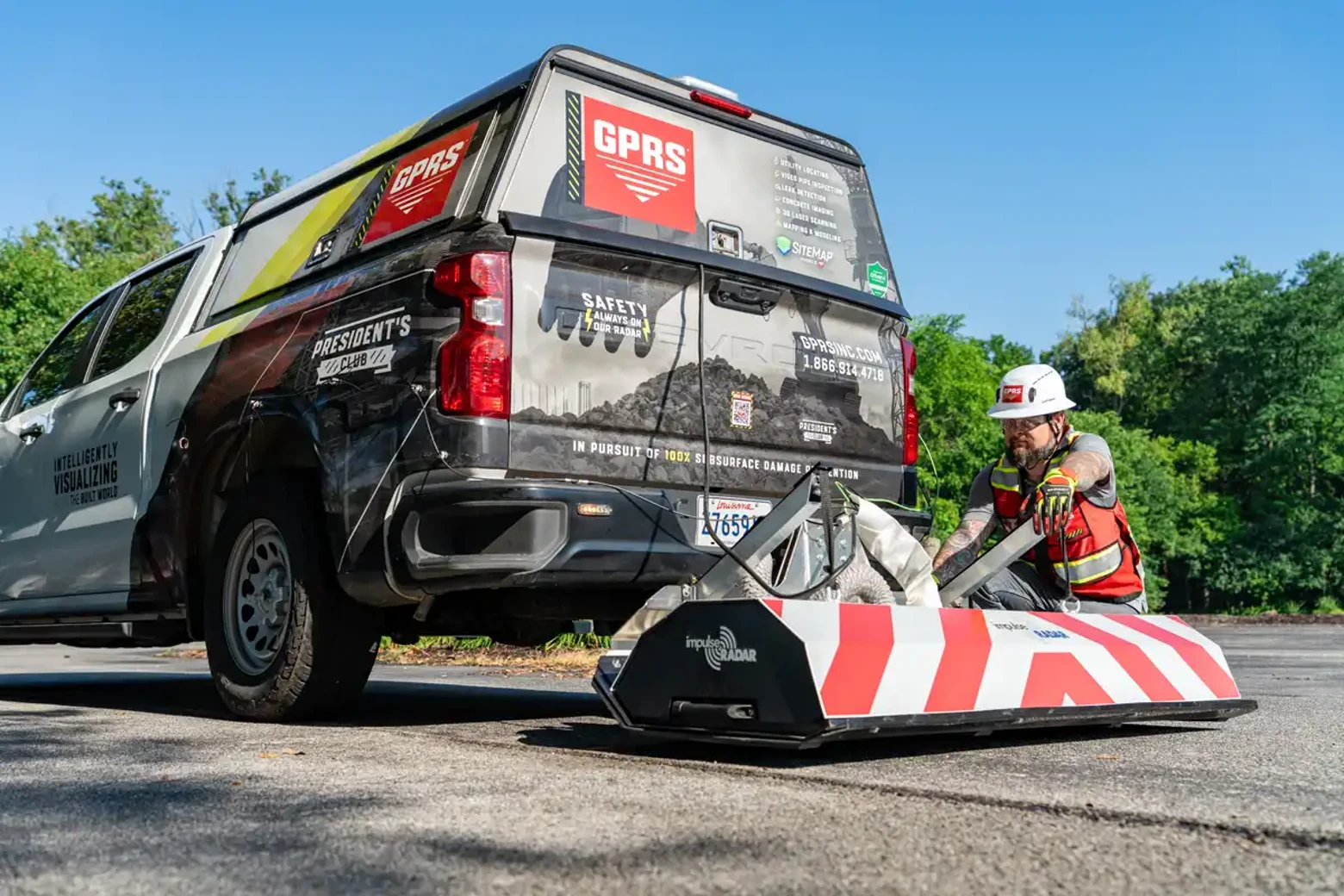 GPRS Project Manager preparing GPR equipment for a subsurface scan on a hot summer day, wearing short sleeves and high-visibility PPE.