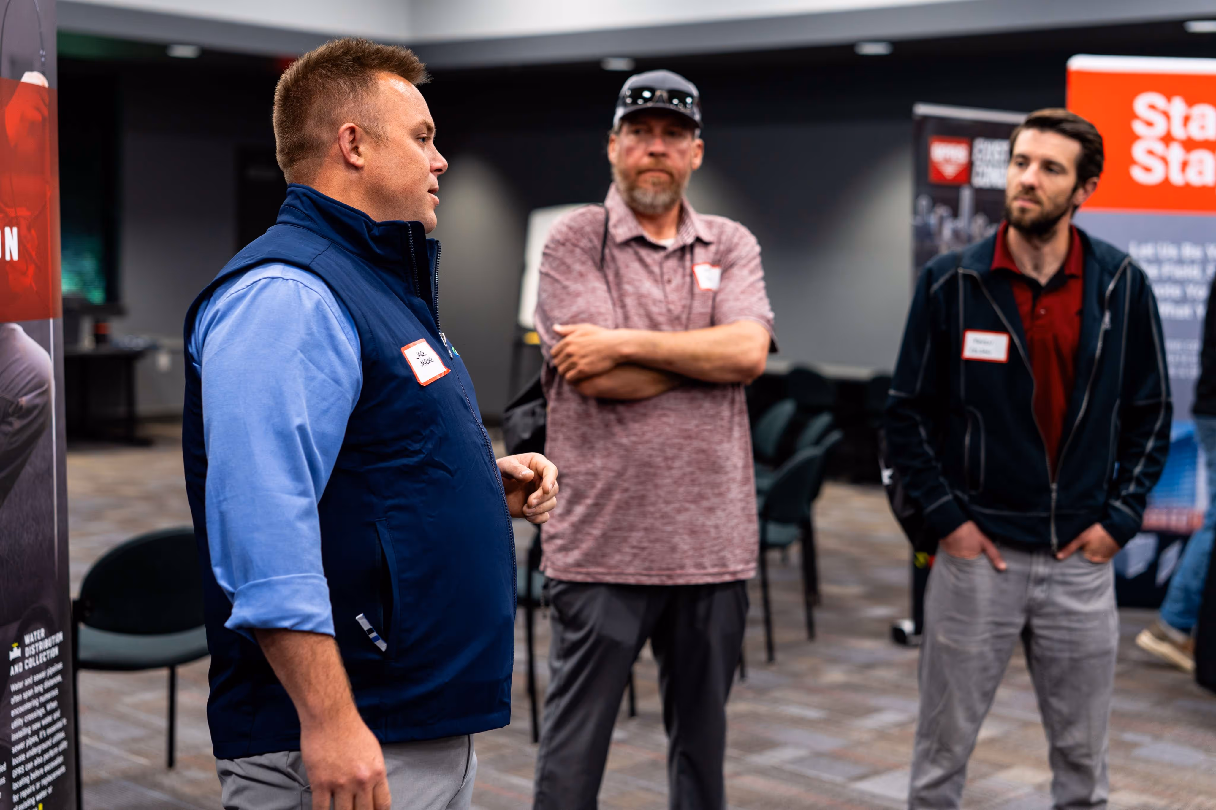 Small group of attendees talks during a GPRS Construction Tech Day event, discussing construction technology, site‑planning tools, and damage‑prevention best practices.